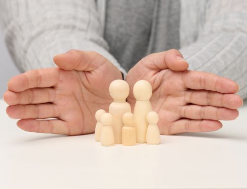 wooden figurines of men, a family guarded by two female hands. Help, life insurance, safety
